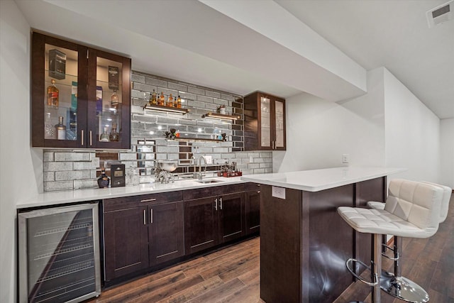 10870 N Spartan Cir, Mequon, WI 53097 - indoor bar featuring wine cooler, dark wood-style flooring, and tasteful backsplash