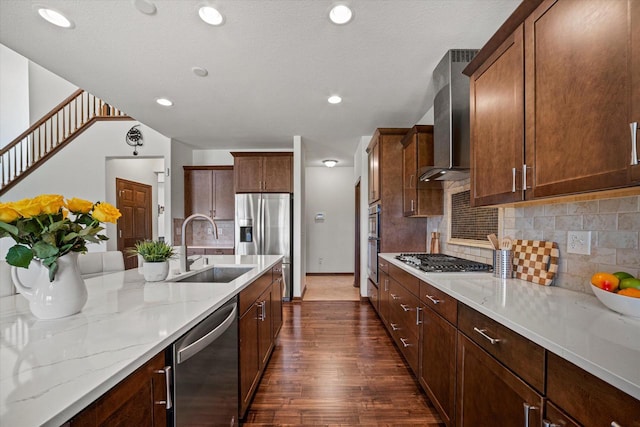 10870 N Spartan Cir, Mequon, WI 53097 - kitchen featuring stainless steel appliances, wall chimney range hood, dark wood-style floors, backsplash, and light stone counters