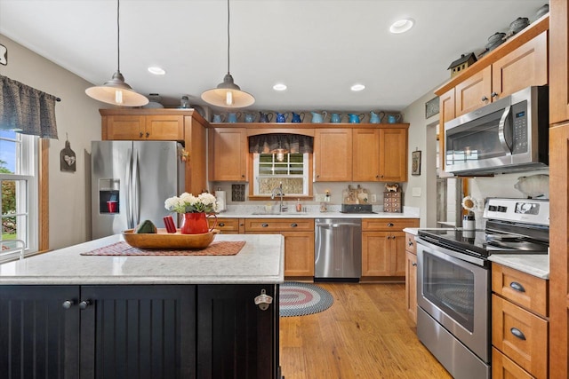 20903 W Main St, Lannon, WI 53046 - kitchen with stainless steel appliances, light wood-type flooring, a center island, decorative light fixtures, and recessed lighting