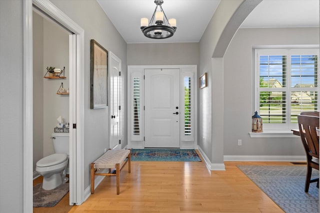 8061 S River Ln, Franklin, WI 53132 - entrance foyer featuring arched walkways, light wood finished floors, and a chandelier