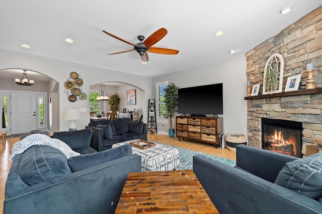 8061 S River Ln, Franklin, WI 53132 - living room featuring arched walkways, wood finished floors, ceiling fan, a stone fireplace, and recessed lighting
