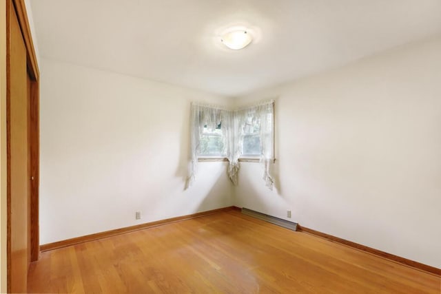1313 S 26th St, Manitowoc, WI 54220 - empty room featuring light wood finished floors and baseboard heating