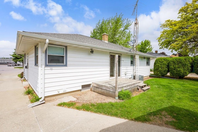 1313 S 26th St, Manitowoc, WI 54220 - back of house with a lawn, a chimney, and a shingled roof