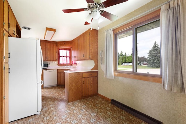 1313 S 26th St, Manitowoc, WI 54220 - kitchen with white appliances, a peninsula, brown cabinets, and light countertops