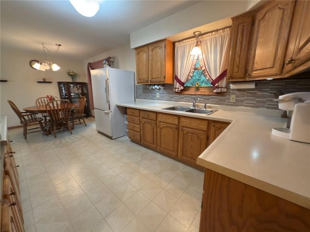 1623 Edgewood Ln, Eau Claire, WI 54703 - kitchen featuring freestanding refrigerator, brown cabinets, decorative backsplash, and light countertops