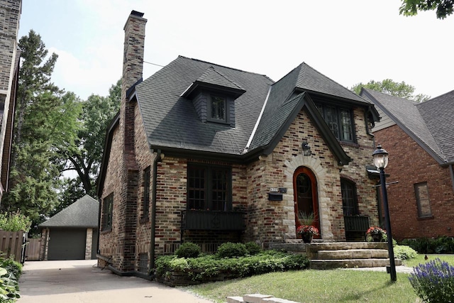 6309 W Mckinley Ave, Wauwatosa, WI 53213 - tudor-style house featuring brick siding, a chimney, roof with shingles, and a garage