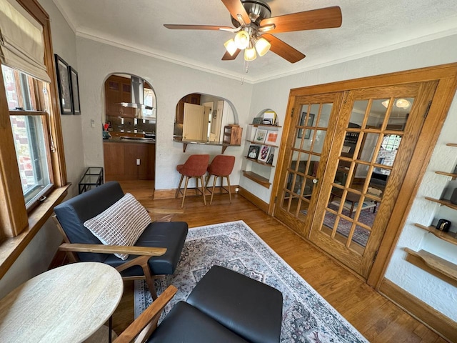 6309 W Mckinley Ave, Wauwatosa, WI 53213 - living area featuring arched walkways, a ceiling fan, wood finished floors, and crown molding