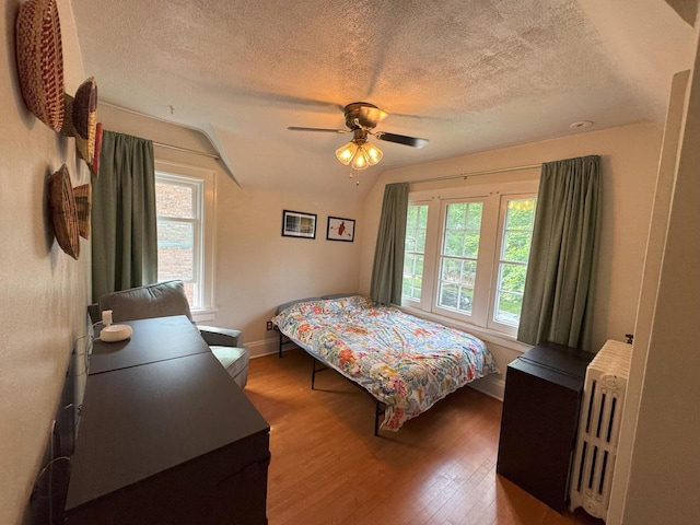 6309 W Mckinley Ave, Wauwatosa, WI 53213 - bedroom featuring wood finished floors, a textured ceiling, radiator, a ceiling fan, and lofted ceiling