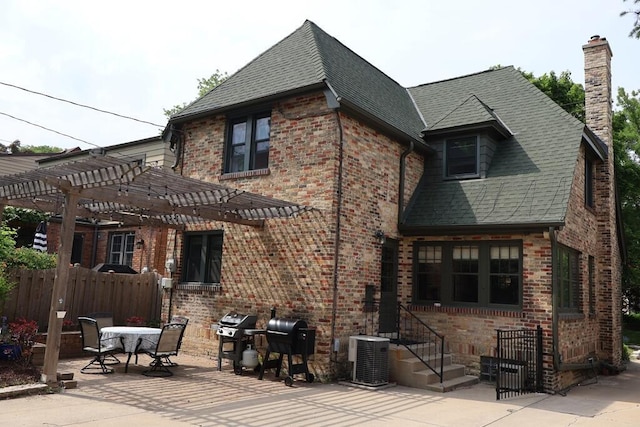 6309 W Mckinley Ave, Wauwatosa, WI 53213 - rear view of house featuring a chimney, a pergola, a patio area, brick siding, and roof with shingles