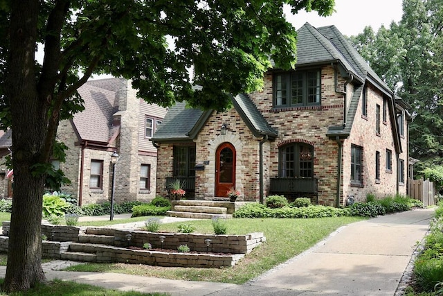 6309 W Mckinley Ave, Wauwatosa, WI 53213 - tudor-style house with brick siding and a front yard