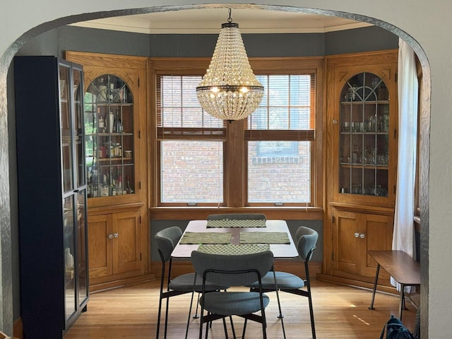 6309 W Mckinley Ave, Wauwatosa, WI 53213 - dining area featuring arched walkways, light wood-type flooring, ornamental molding, and plenty of natural light