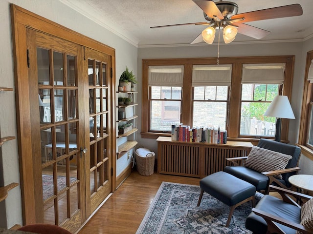 6309 W Mckinley Ave, Wauwatosa, WI 53213 - sitting room featuring ceiling fan, wood finished floors, ornamental molding, and radiator