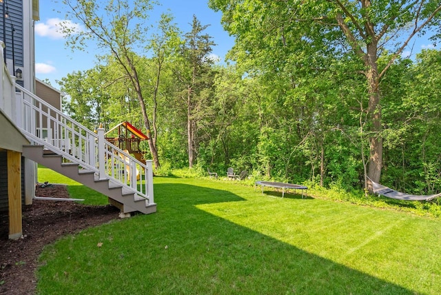 309 Paradise Ct, Hartland, WI 53029 - view of grassy yard featuring a trampoline and stairs