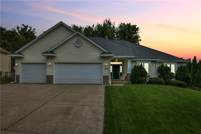 3614 Greendale Ct, Eau Claire, WI 54701 - view of front of home featuring concrete driveway, a garage, a front yard, and stone siding