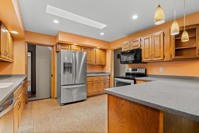 1635 N 21st St, Manitowoc, WI 54220 - kitchen with appliances with stainless steel finishes, a skylight, hanging light fixtures, recessed lighting, and brown cabinetry