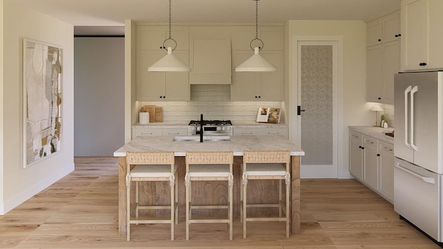905 Westbridge Ct, Waunakee, WI 53597 - kitchen featuring high quality fridge, decorative backsplash, decorative light fixtures, and light wood-type flooring