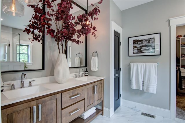 6649 Hope Ln, Eau Claire, WI 54701 - bathroom featuring double vanity, marble finish flooring, and a walk in closet