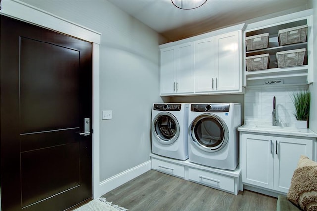 6649 Hope Ln, Eau Claire, WI 54701 - laundry area featuring cabinet space, independent washer and dryer, and light wood-style floors