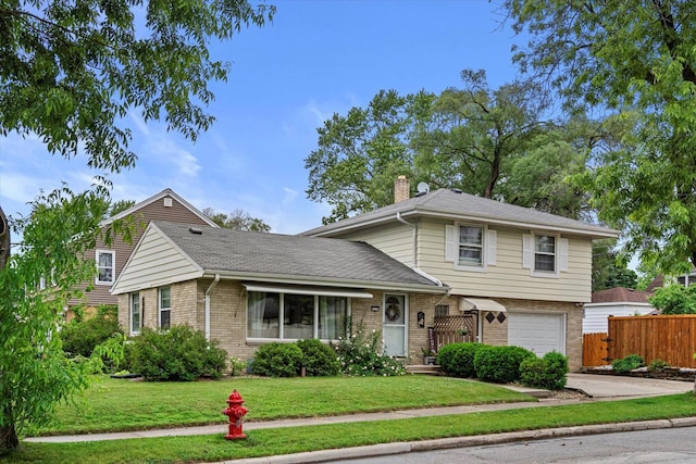 9230 W Auer Ave, Milwaukee, WI 53222 - split level home with brick siding, a garage, a chimney, and concrete driveway