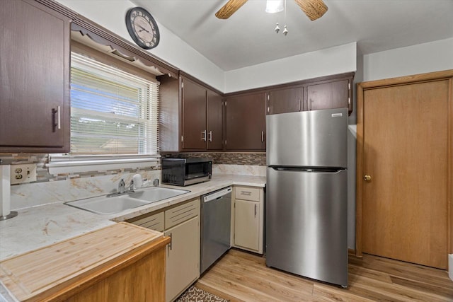 9230 W Auer Ave, Milwaukee, WI 53222 - kitchen featuring stainless steel appliances, dark brown cabinets, ceiling fan, light wood-style floors, and decorative backsplash