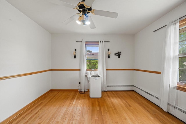 9230 W Auer Ave, Milwaukee, WI 53222 - unfurnished room featuring light wood-style floors, plenty of natural light, a ceiling fan, and a baseboard radiator