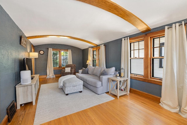 1441 N 66th St, Wauwatosa, WI 53213 - living area with light wood-type flooring, vaulted ceiling, arched walkways, and a textured wall