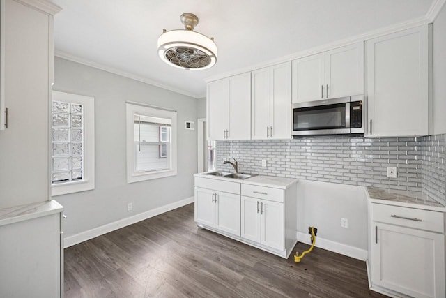 3936 N 14th St Unit 3938, Milwaukee, WI 53206 - kitchen with stainless steel microwave, light countertops, dark wood finished floors, crown molding, and decorative backsplash