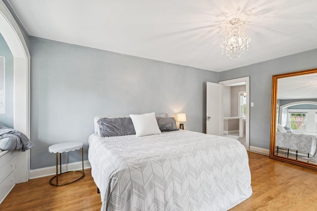 509 S 6th Ave, West Bend, WI 53095 - bedroom with wood finished floors, arched walkways, and a chandelier