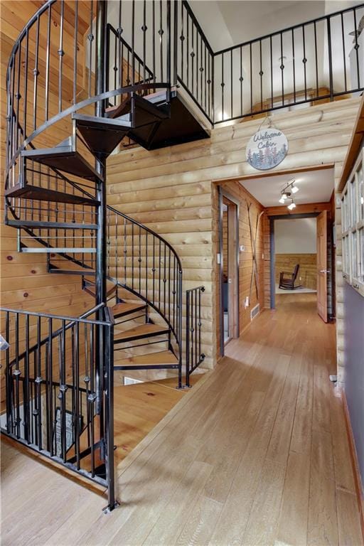 5683N Ham-Holly Dr, Stone Lake, WI 54876 - stairway featuring hardwood / wood-style floors, rustic walls, and a high ceiling