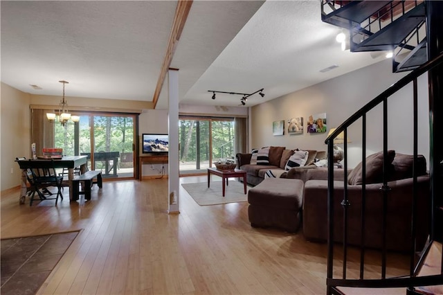 5683N Ham-Holly Dr, Stone Lake, WI 54876 - living room with a chandelier, light wood-style flooring, rail lighting, and a textured ceiling