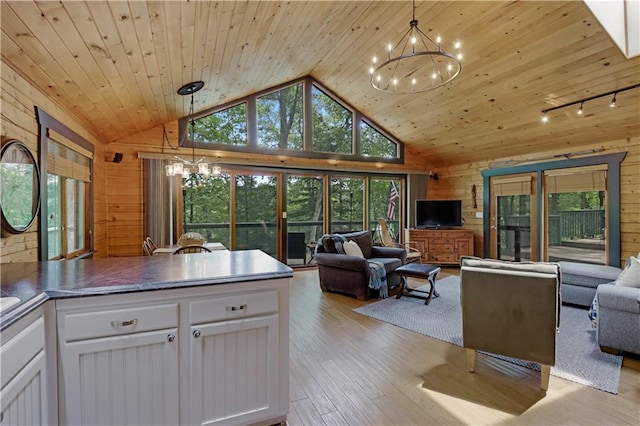 5683N Ham-Holly Dr, Stone Lake, WI 54876 - kitchen with open floor plan, a chandelier, wooden walls, white cabinets, and light wood-style floors