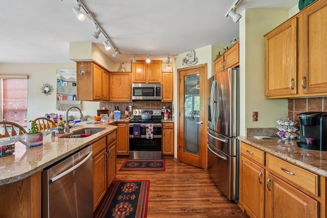 8216 Anna Ave, Wind Lake, WI 53185 - kitchen featuring appliances with stainless steel finishes, track lighting, dark wood-style floors, brown cabinets, and light stone counters