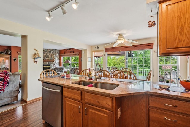 8216 Anna Ave, Wind Lake, WI 53185 - kitchen with stainless steel dishwasher, brown cabinets, dark wood finished floors, ceiling fan, and light stone counters