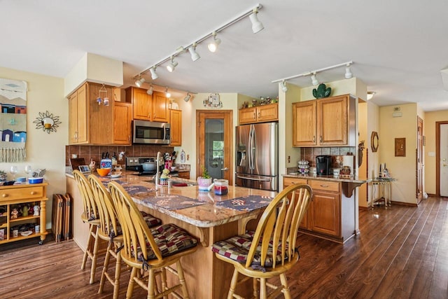 8216 Anna Ave, Wind Lake, WI 53185 - kitchen with appliances with stainless steel finishes, a peninsula, a breakfast bar area, and rail lighting