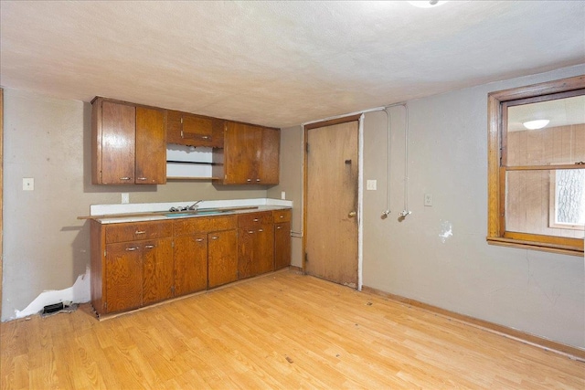 1507 N Peach Ave, Marshfield, WI 54449 - kitchen featuring brown cabinets, light wood-type flooring, and light countertops