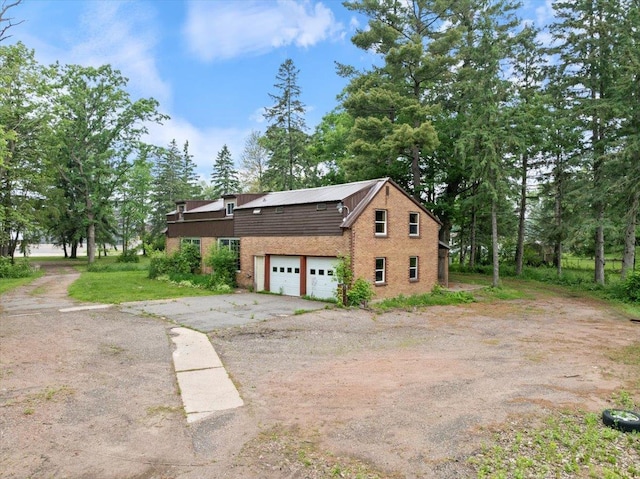 1507 N Peach Ave, Marshfield, WI 54449 - view of side of property featuring a garage, asphalt driveway, and brick siding