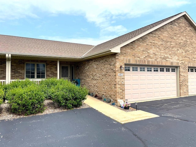 1216 Pond View Cir, De Pere, WI 54115 - single story home with brick siding, an attached garage, asphalt driveway, and roof with shingles