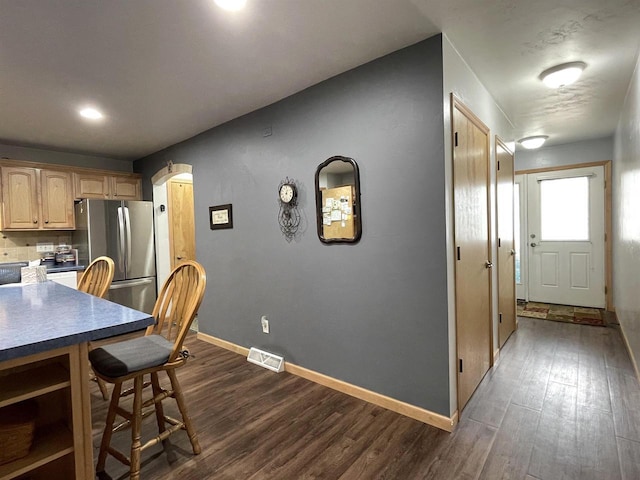 1216 Pond View Cir, De Pere, WI 54115 - kitchen featuring freestanding refrigerator, dark wood-type flooring, a kitchen bar, and arched walkways