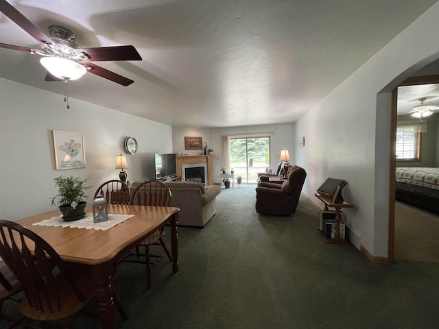 1216 Pond View Cir, De Pere, WI 54115 - dining space featuring ceiling fan, carpet flooring, arched walkways, and a fireplace