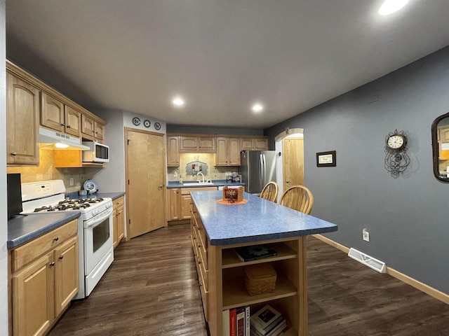 1216 Pond View Cir, De Pere, WI 54115 - kitchen featuring white appliances, under cabinet range hood, dark countertops, a center island, and recessed lighting
