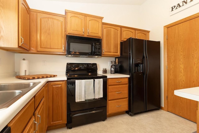 2137 Olde Country Cir, Kaukauna, WI 54130 - kitchen featuring black appliances, light countertops, light tile patterned floors, and brown cabinets