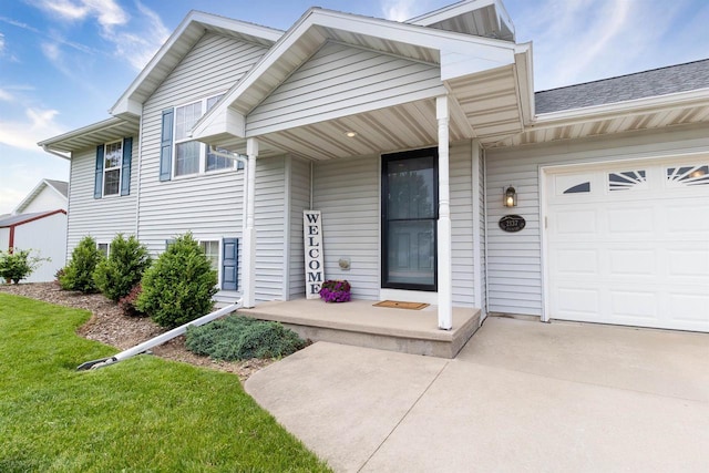 2137 Olde Country Cir, Kaukauna, WI 54130 - view of exterior entry with a garage, concrete driveway, and covered porch