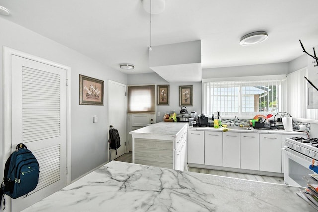 5628 W Montana St, Milwaukee, WI 53219 - kitchen featuring white gas range, healthy amount of natural light, light wood-style flooring, and white cabinetry