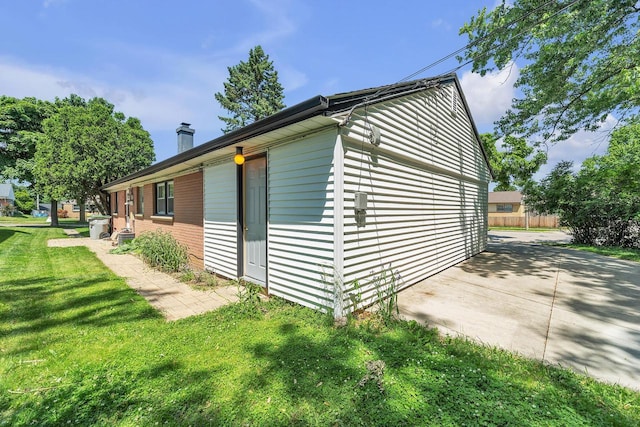 5531 W Stack Dr, Milwaukee, WI 53219 - view of side of home featuring a chimney, a lawn, and a patio