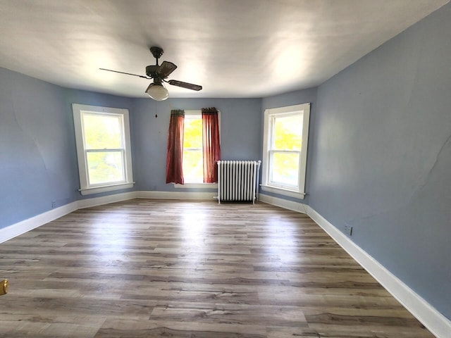 1528 Taylor Ave, Racine, WI 53403 - spare room featuring radiator heating unit, ceiling fan, and wood finished floors