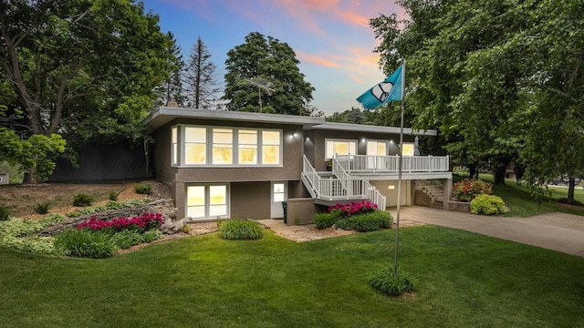 1242 E Edgewood Dr, Appleton, WI 54913 - view of front of home with stairs, concrete driveway, a lawn, stucco siding, and a garage