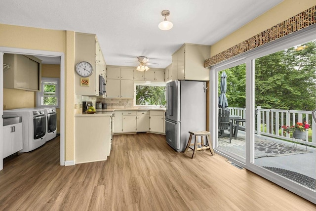 1242 E Edgewood Dr, Appleton, WI 54913 - kitchen featuring washer and dryer, stainless steel appliances, light wood finished floors, ceiling fan, and light countertops