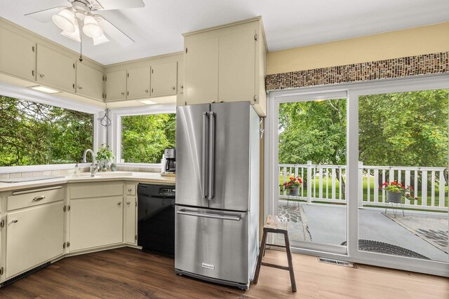 1242 E Edgewood Dr, Appleton, WI 54913 - kitchen with freestanding refrigerator, dishwasher, dark wood-style flooring, cream cabinetry, and a ceiling fan