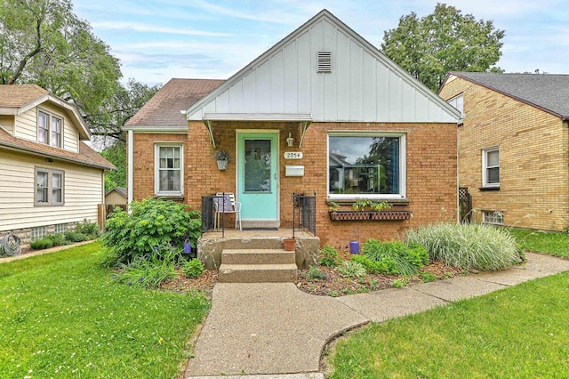 2954 S 48th St, Milwaukee, WI 53219 - bungalow-style home with board and batten siding, a front yard, and brick siding