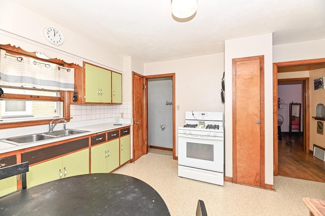 2954 S 48th St, Milwaukee, WI 53219 - kitchen with gas range gas stove, green cabinetry, light countertops, and decorative backsplash